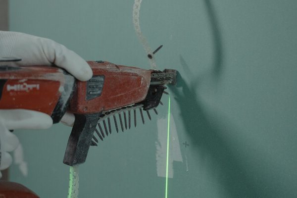 Plasterboard being fixed with a screw gun